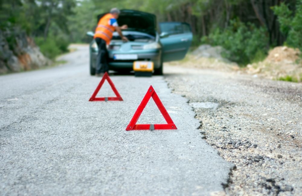 Safety triangles from car emergency kit help warn other drivers when your car is on the side of the road