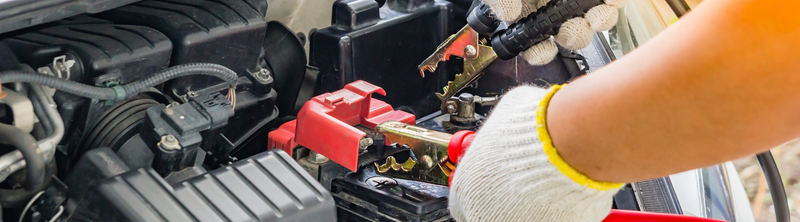 Hands jump starting a car battery. 