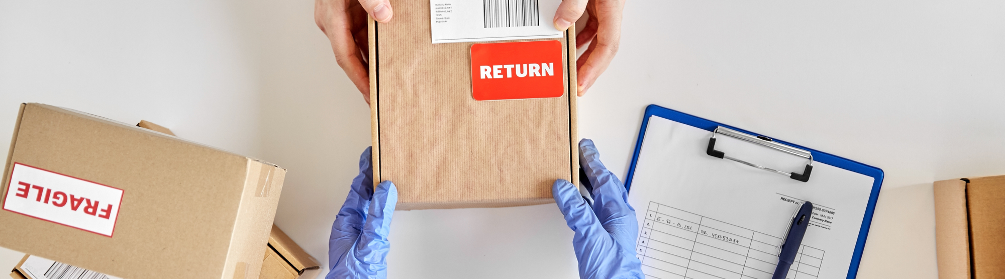 Hands in blue gloves processing a labeled return package for Safety Kits Plus's guarantee and returns policy